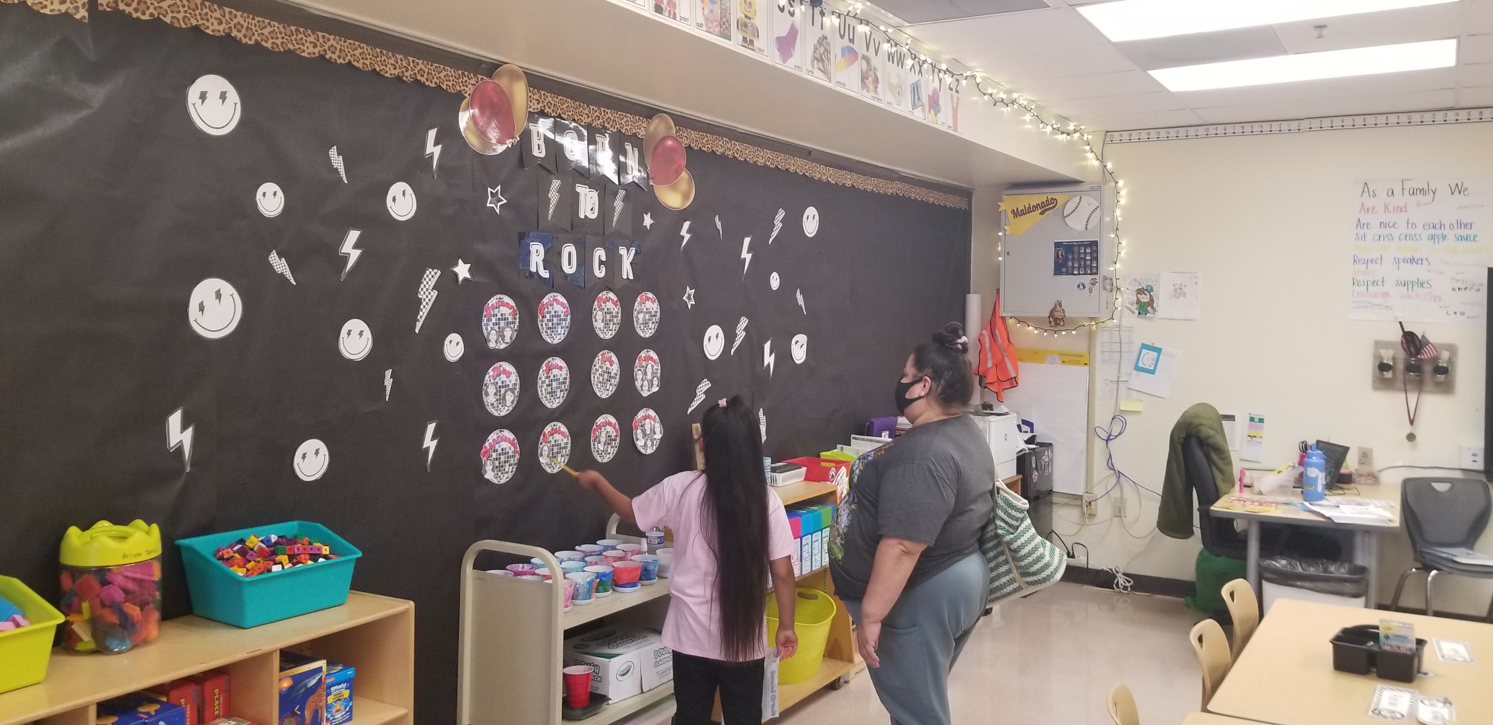 A little girl points at the board during Open House