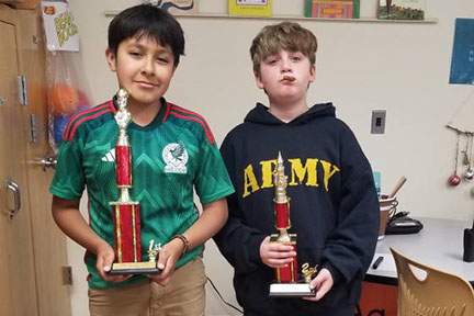Two boys smile with their trophies