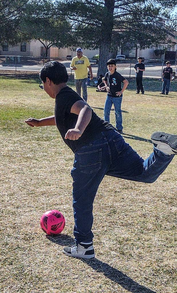 A boy kicks a soccer ball