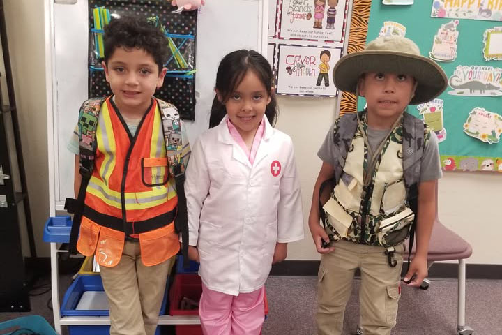 Three young students dressed in costumes for their future career