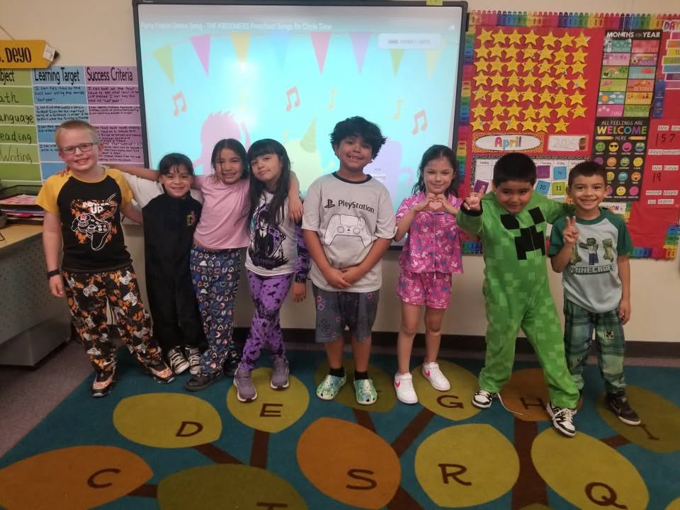 Students in a classroom show off their pajamas for spirit week