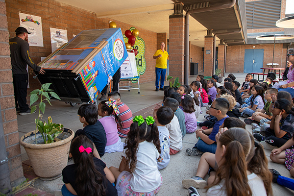Students watch excitedly as the book vending machine is rolled into the courtyard